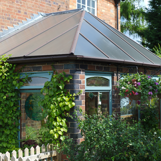 Conservatory covered in shrubs and climbing garden plants